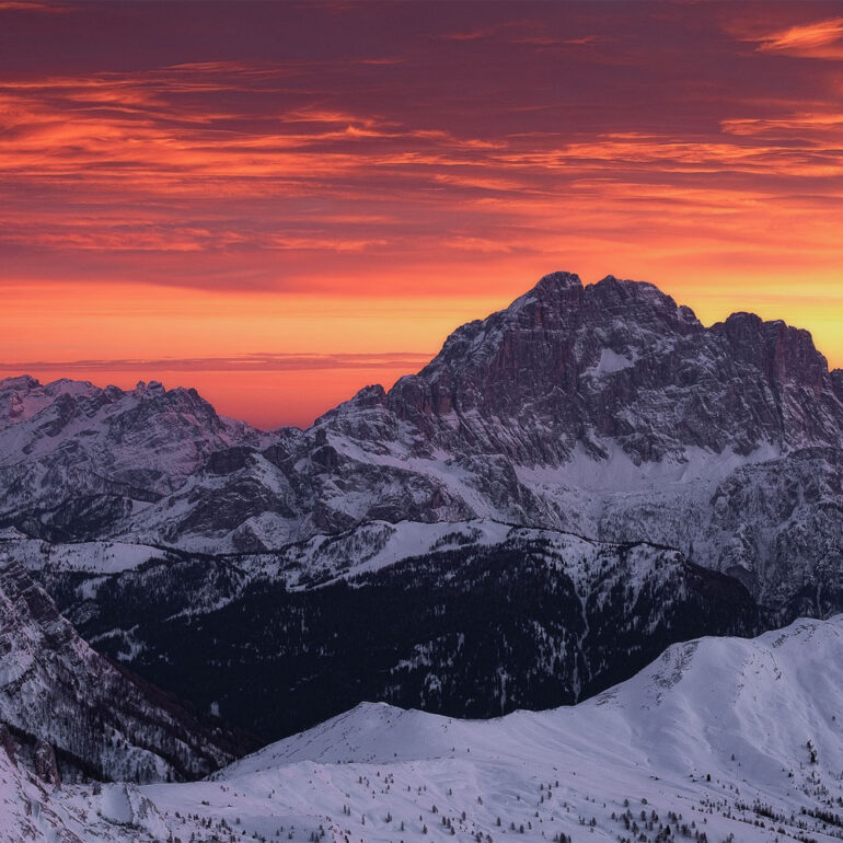 The snow-covered Marmolada glowing beneath a fiery winter sunset, photographed from Lagazuoi in the UNESCO-listed Italian Dolomites.