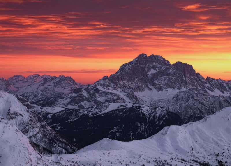 The snow-covered Marmolada glowing beneath a fiery winter sunset, photographed from Lagazuoi in the UNESCO-listed Italian Dolomites.