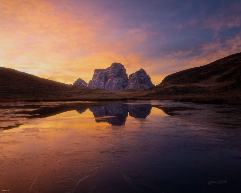 A colourful sunrise over Lago delle Baste with Monte Pelmo rising in the background, reflected in the calm waters of the Italian Dolomites.