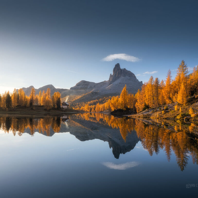 Home The golden larch forests surrounding Lago Federa reflecting the majestic Becco di Mezzodì during a colourful autumn sunrise in the Italian Dolomites.