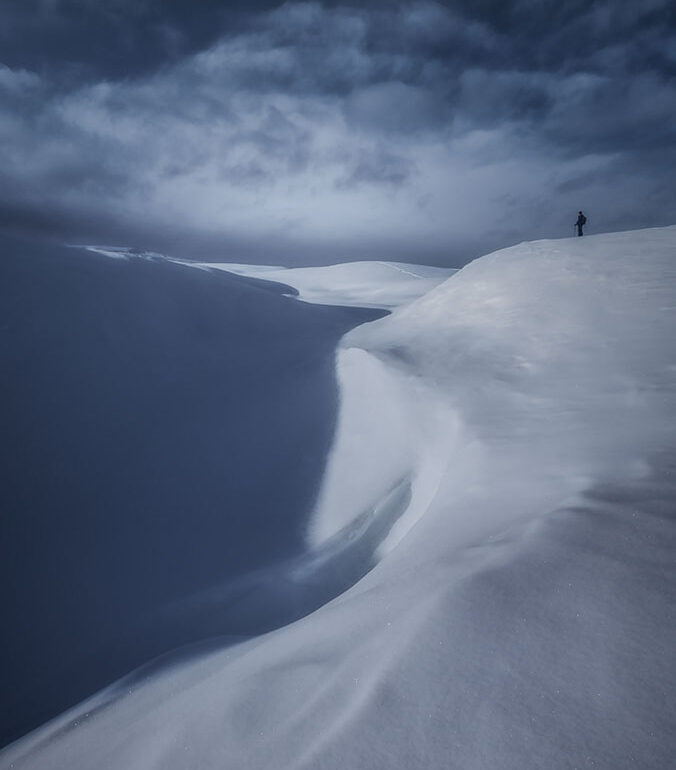 A winter hiker walking through fresh snowfall on Monte Piana in the UNESCO-listed Italian Dolomites.