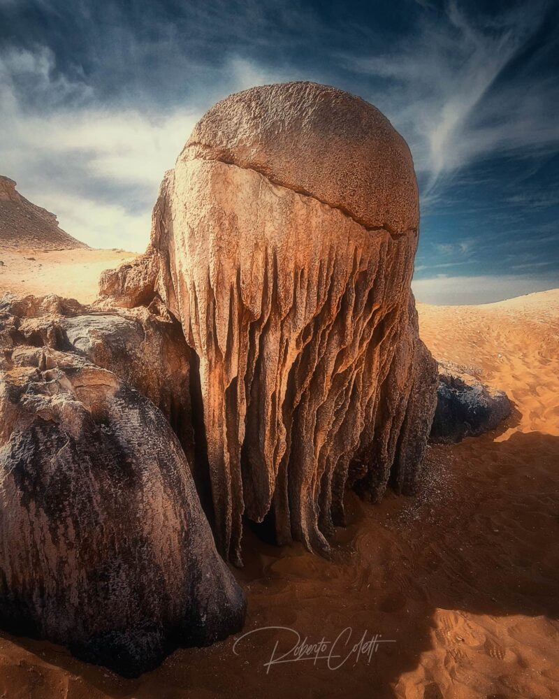The iconic Medusa Rock, a sculpted white chalk formation in White Desert National Park, Egypt, illuminated by soft golden light.