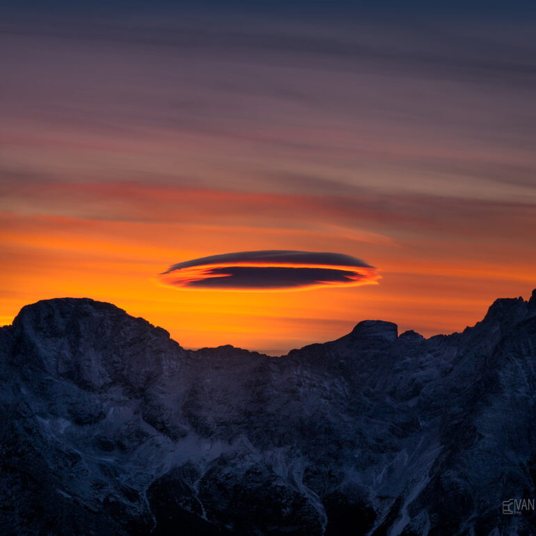 A rare lenticular cloud forming above Monte Rite in the UNESCO-listed Dolomites, Italy, creating a spectacular mountain weather phenomenon.