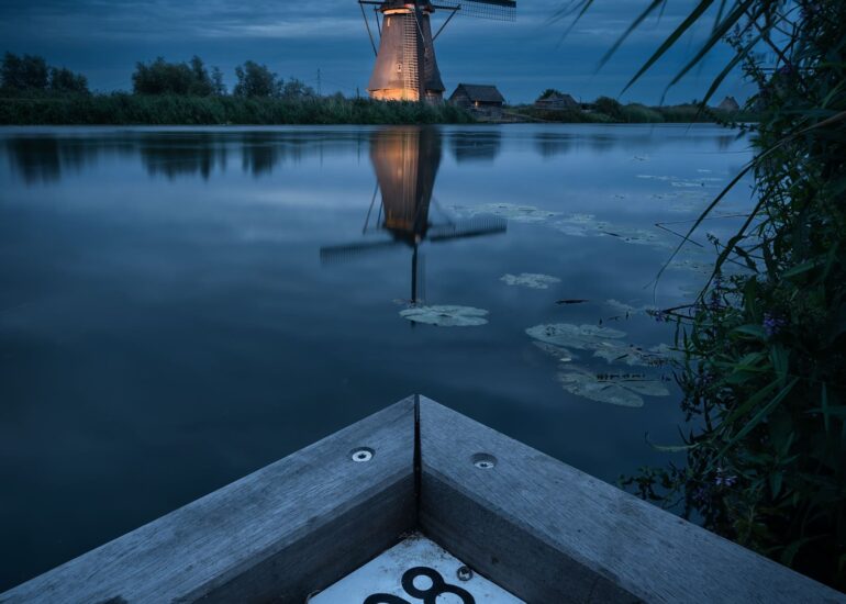 Traditional Dutch windmills beautifully illuminated at night during Kinderdijk Illumination Week in the Netherlands.