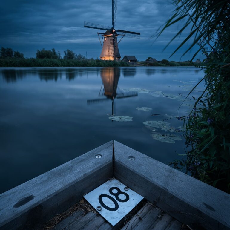 Traditional Dutch windmills beautifully illuminated at night during Kinderdijk Illumination Week in the Netherlands.