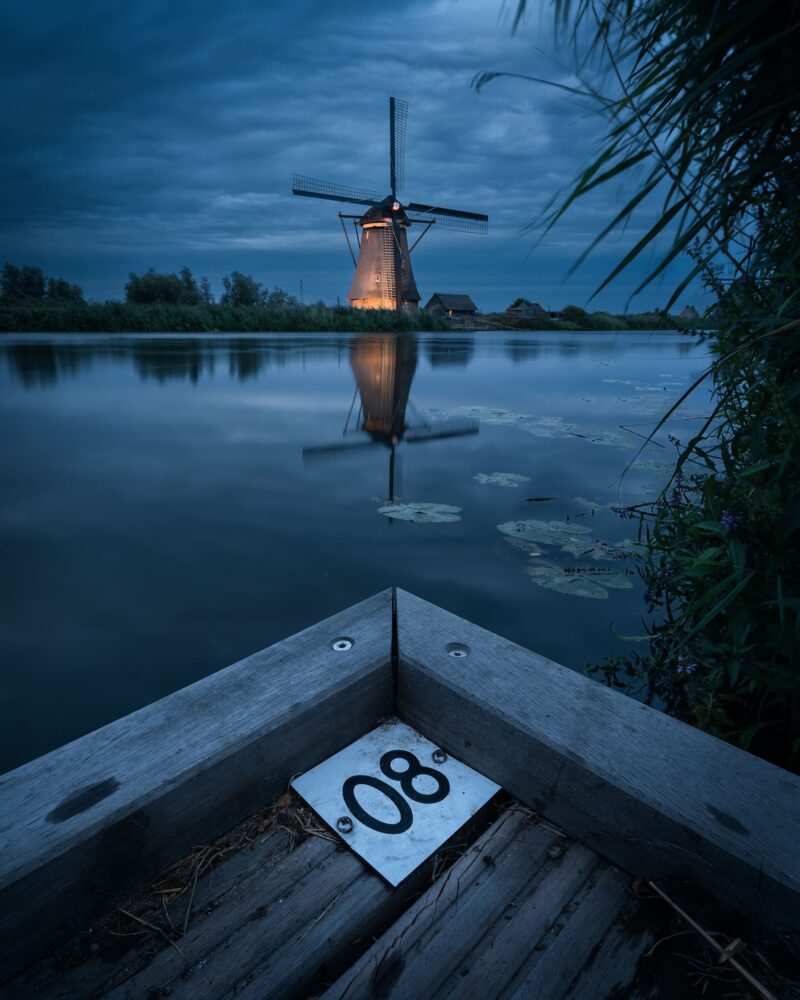 Traditional Dutch windmills beautifully illuminated at night during Kinderdijk Illumination Week in the Netherlands.
