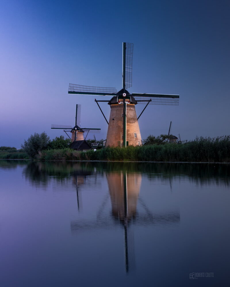 Historic windmills illuminated during Kinderdijk Illumination Week, creating a magical nighttime atmosphere in the Netherlands.