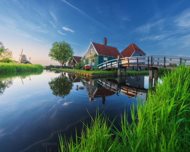 Traditional green wooden house and charming bridge in Zaanse Schans during spring, one of the most iconic historic villages in the Netherlands.