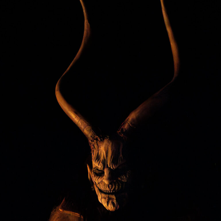 Night procession of Krampus performers through a mountain village in the Italian Dolomites.