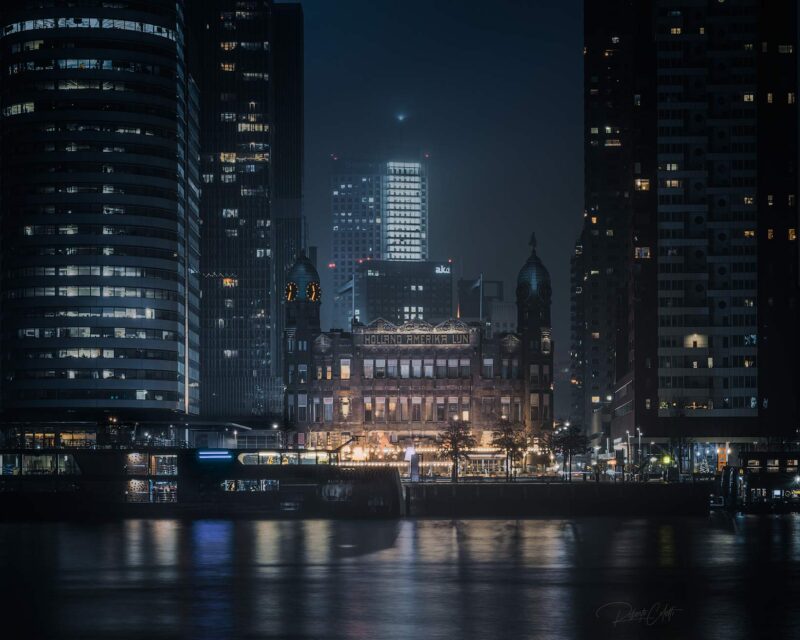 Night skyline of Rotterdam featuring Hotel New York, the former headquarters of the Holland America Line, surrounded by the city