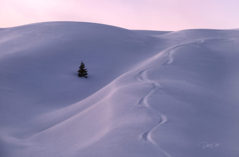 Wind-sculpted snowdrifts in the Dolomites, Italy, during a cold winter morning with soft mountain light.