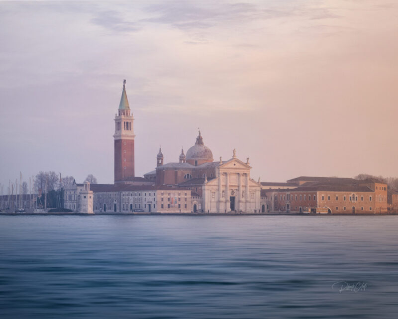 Sunset over San Giorgio Maggiore photographed from Riva degli Schiavoni, with golden light reflecting across the Venetian Lagoon in Venice, Italy.